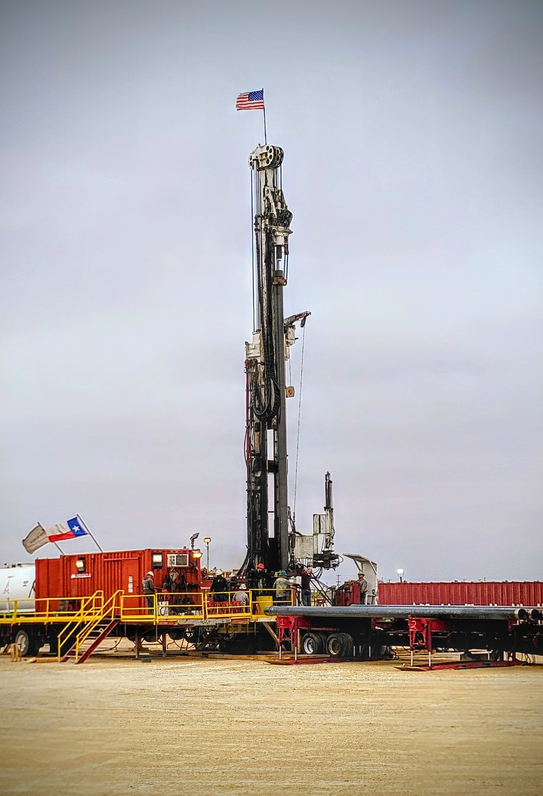 Spudder rig operations with American and Texas flags
